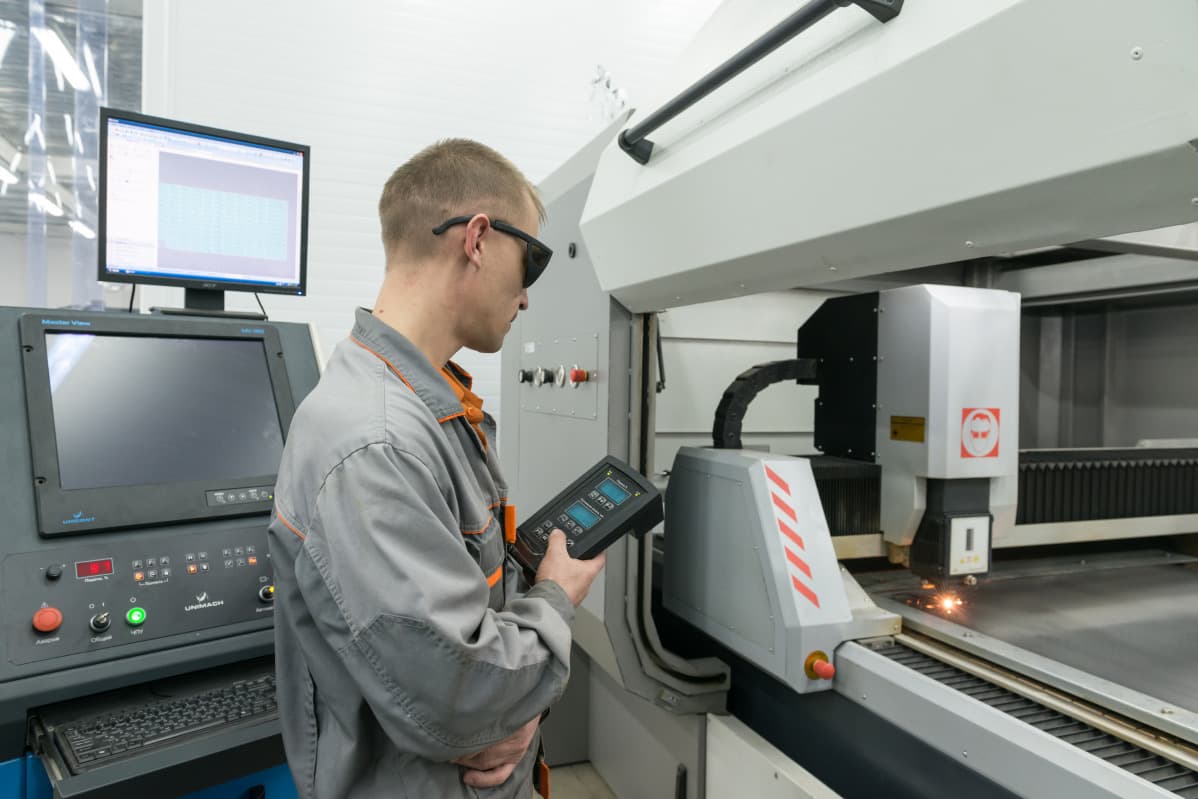 Technician operating precision manufacturing equipment